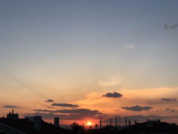 Silhouette buildings against sky during sunset