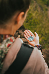 Midsection of woman holding compass outdoors