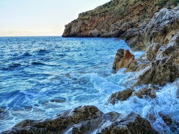 Scenic view of rocks in sea against sky