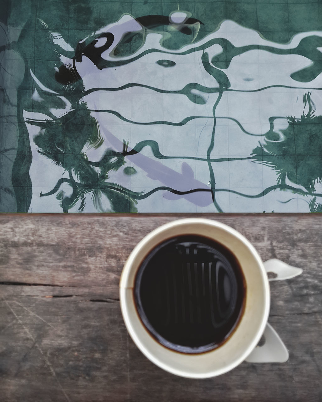 DIRECTLY ABOVE SHOT OF COFFEE CUP ON TABLE AGAINST WALL