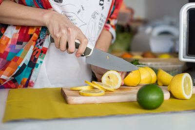 Midsection of man preparing fruits on cutting board