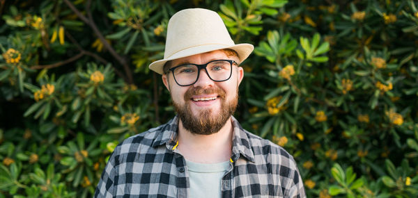 Portrait of young man wearing hat against plants