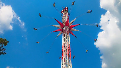 Low angle view of amusement park ride against blue sky