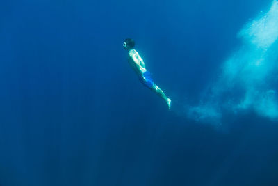 Mid adult woman swimming undersea