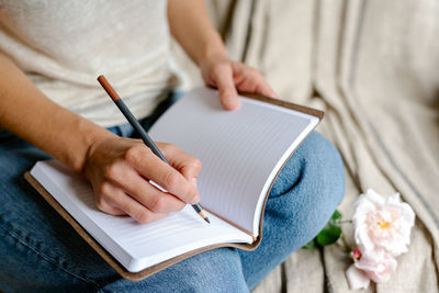 Woman makes notes in a notepad.