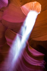 Low angle view of sunlight falling in slot canyon