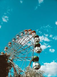 Low angle view of ferris wheel against blue sky