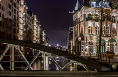 Illuminated city against sky at night