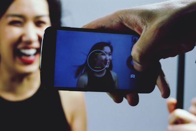 Close-up of young woman holding smart phone