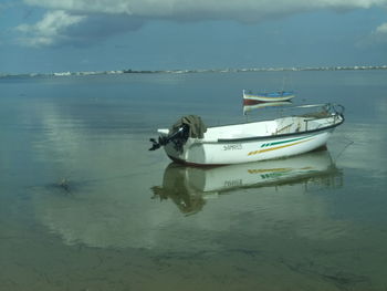 Boat moored on sea against sky