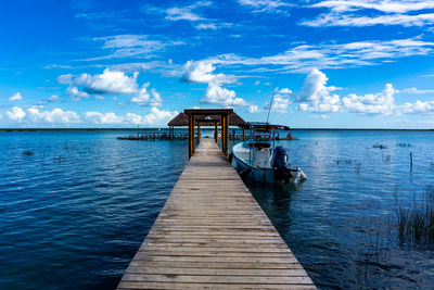 Pier over sea against blue sky