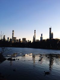 Scenic view of lake by buildings against clear sky