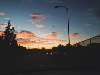 Cars on road against sky during sunset