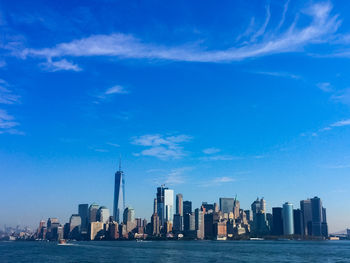Modern buildings in city against blue sky