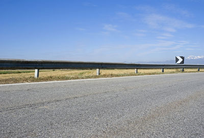 Country road on field against sky