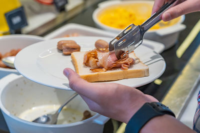 Midsection of person preparing food in plate