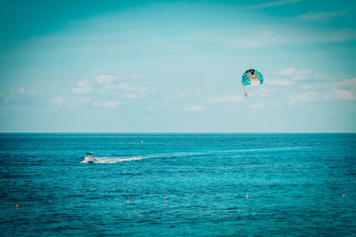 Scenic view parachute above the  sea against sky