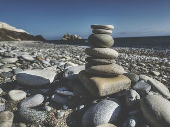 Stack of pebbles on beach against clear sky