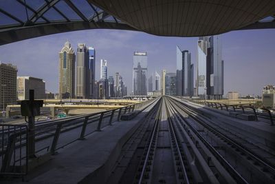 Empty railroad station with city buildings seen in background