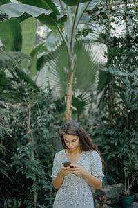 Woman standing against plants