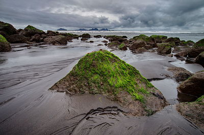 View of beach against cloudy sky