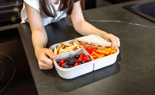 High angle view of woman holding ice cream on table