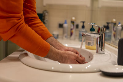 Global handwashing day concept. washing hands with soap under the water tap with water in bathroom.