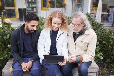 Male and female worker looking at digital tablet in courtyard