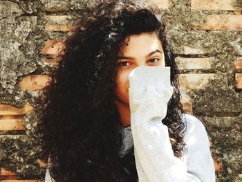 Close-up portrait of girl standing against wall