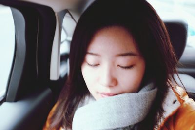 Close-up of young woman sitting in car