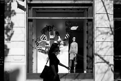 Man and woman walking by window of store