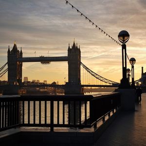 Tower bridge over thames river against sky during sunset