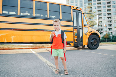 Full length of boy standing in city