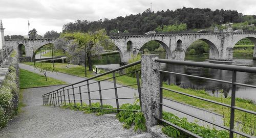 Arch bridge over river against sky