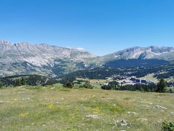 Scenic view of field against clear blue sky