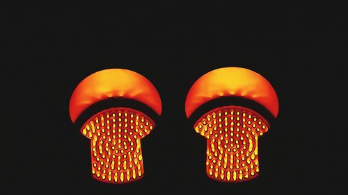 Close-up of illuminated lighting equipment against black background