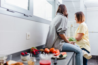 Cheerful women preparing food in kitchen