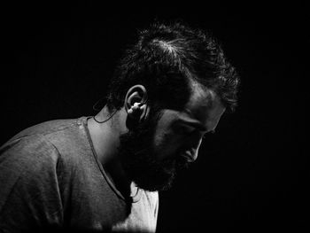 Side view of serious man sitting in darkroom