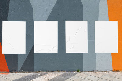 Geometrical wall and four white glued wrinkled poster templates