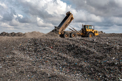 A dumper truck on a large waste management landfill site dumping rubbish in an environmental issue 