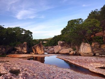 Rock formation amidst trees against sky