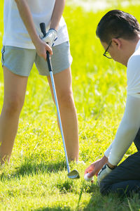 Full length of couple playing golf on field