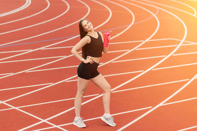 Full length of woman running on soccer field