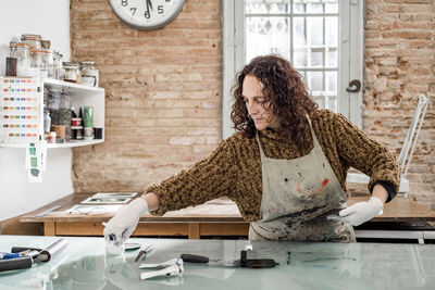 Female artist preparing a plate for an art print.