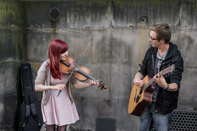 Full length of a woman playing guitar