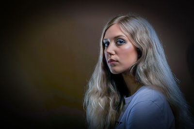 Portrait of beautiful young woman against colored background