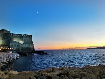 Scenic view of  castel dell'ovo against sky at sunset