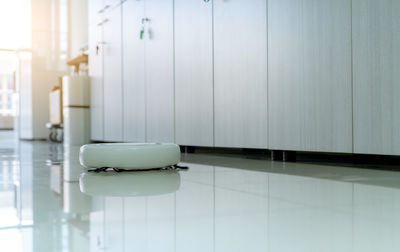 Robot vacuum cleaner cleaning floor in office. white robot vacuum cleaner for the smart home.