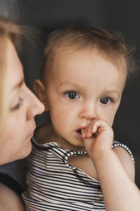 Portrait of baby boy with mother at home