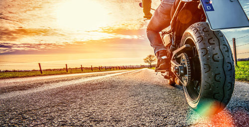 Low section of man riding bicycle on road